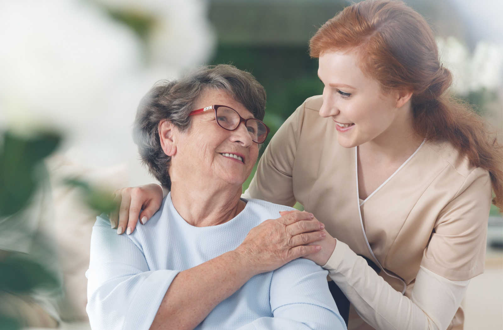 A skilled caregiver helping a senior woman in her daily activities.